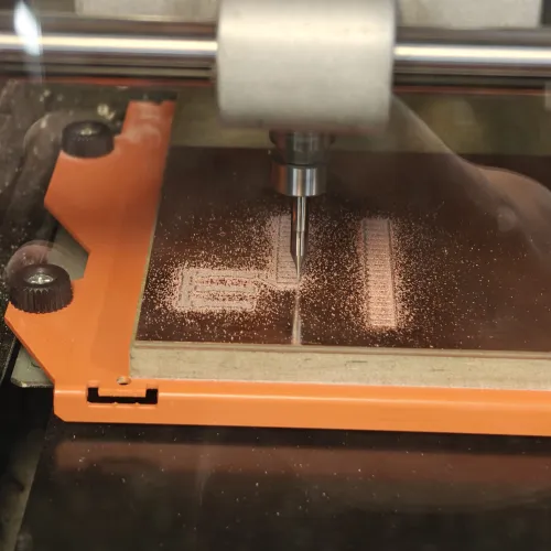 SRM-20 milling in progress, copper dust accumulating on the board as traces are carved