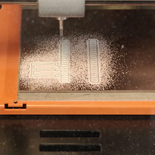 Second milling pass in progress with deeper Z setting, more copper dust visible