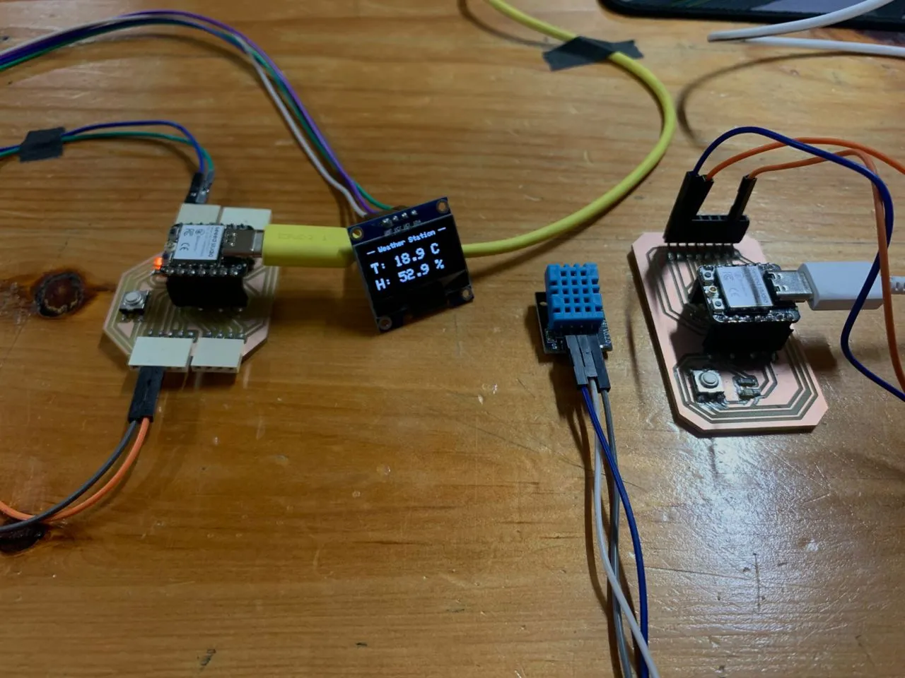 Hero shot — both boards running, OLED showing Weather Station data