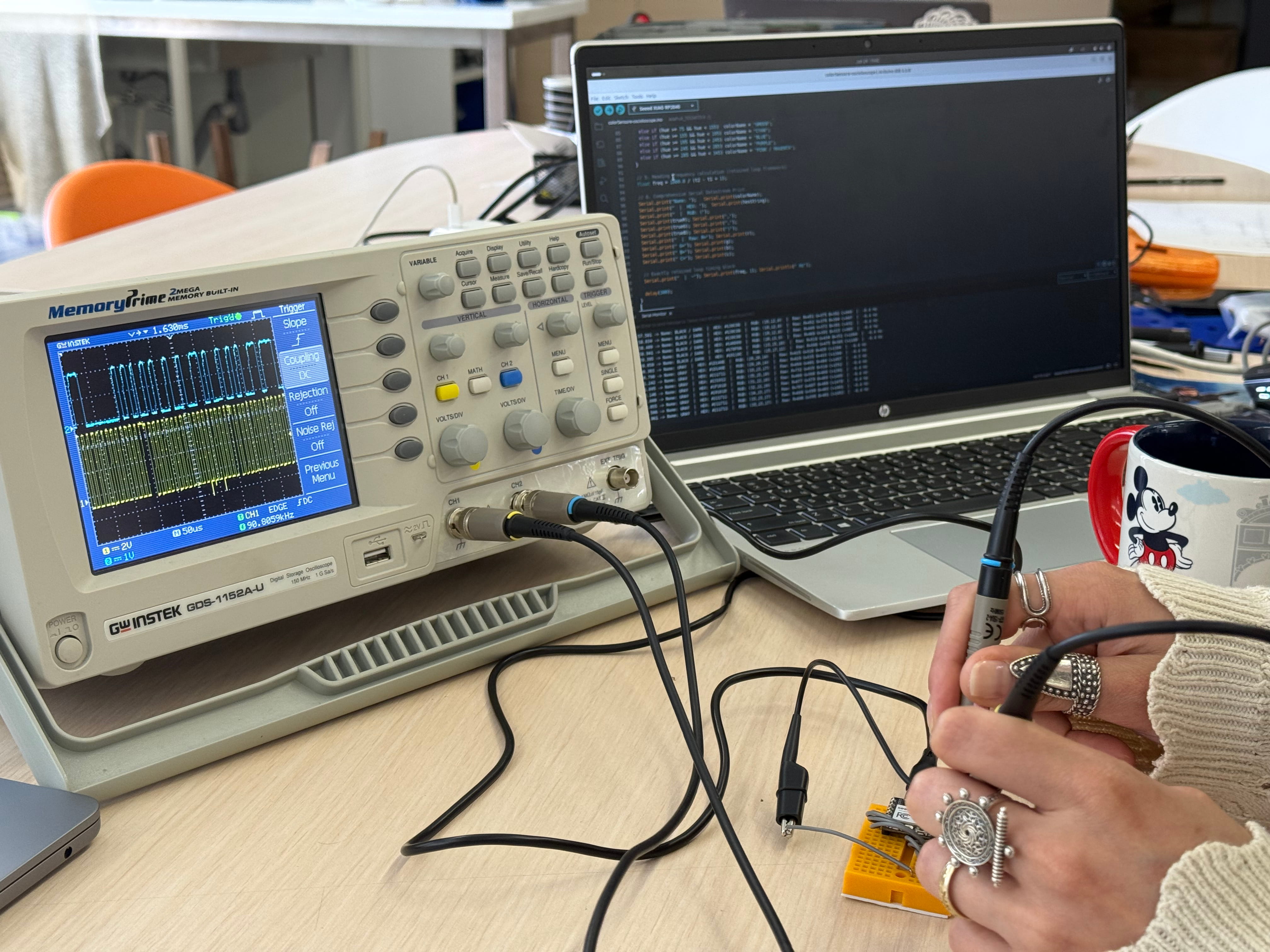 Full setup โ oscilloscope, laptop serial monitor, and sensor
