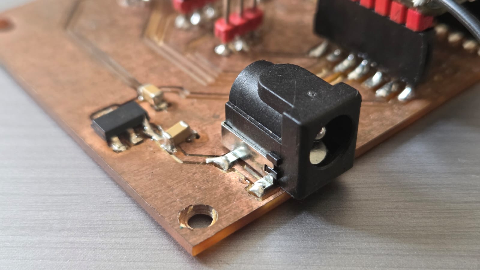 Close-up of the barrel jack solder joints and regulator placement