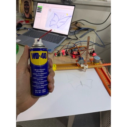 Title: image11.jpeg - Description: The orange warm-up plotter drawing its first butterfly — a drop of WD-40 on the rods was the difference between jittery lines and clean ones.