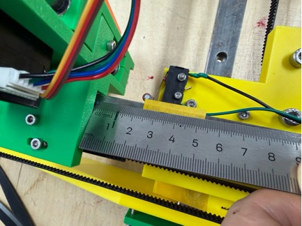 Title: image18.jpeg - Description: Belt tension and endstop being fitted — ruler used to check that the carriage travel matches the expected work area.