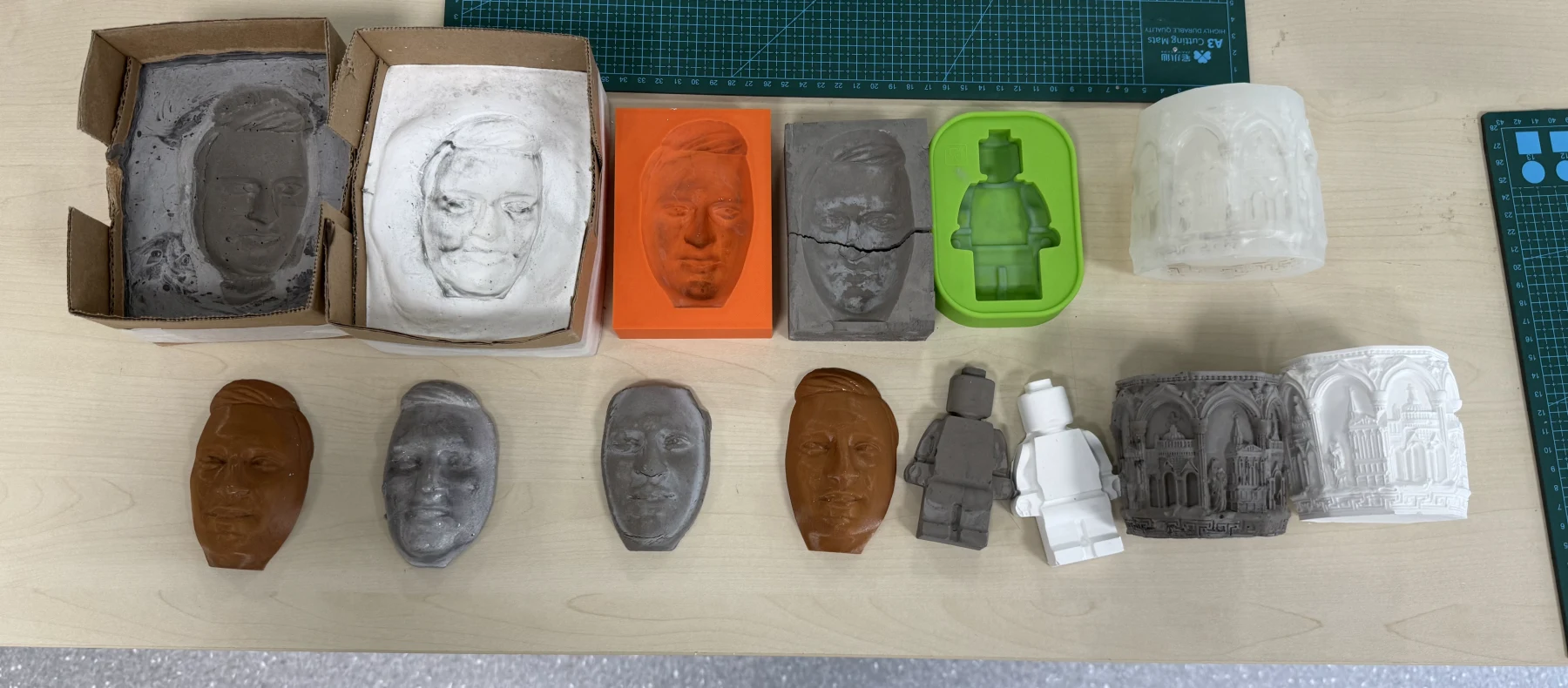 Overview of Week 14 molding and casting results including plaster, mortar, tin, PLA, moulds, and cast figures