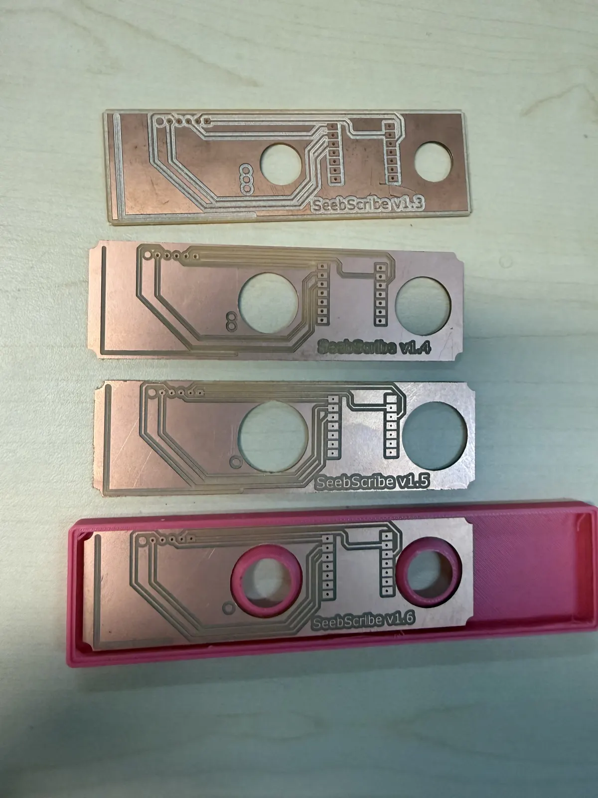 Several iterations of the Seebscribe carrier PCB and enclosure