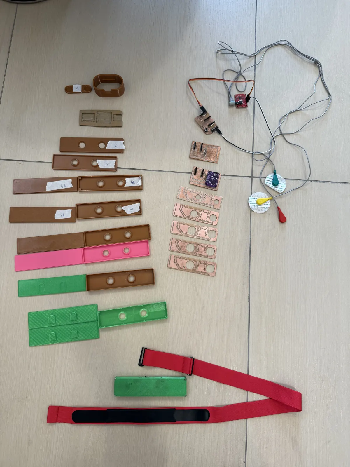 Collection of PCB, enclosure, electrode, and strap prototypes