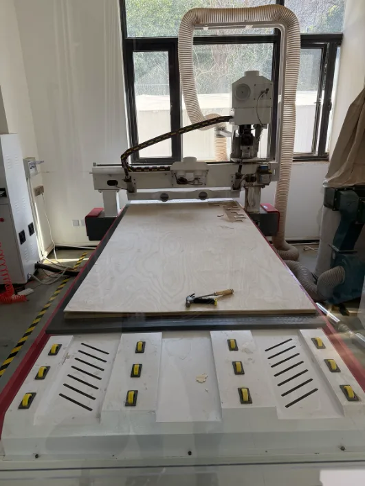 CNC machine with plywood sheet on the bed
