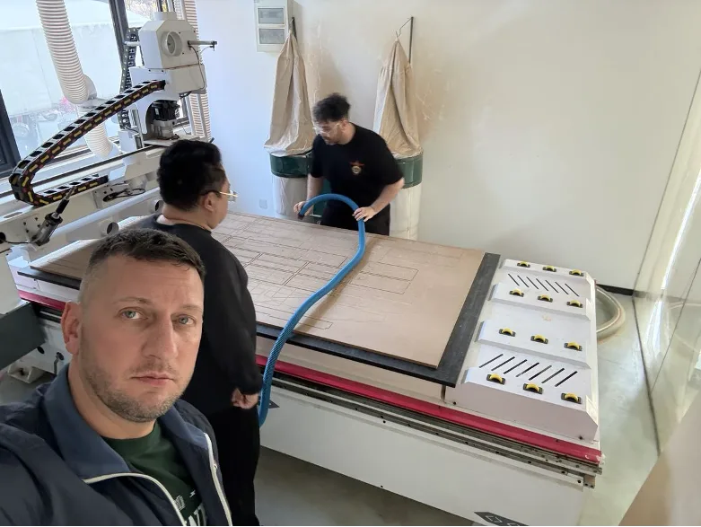Team cleaning the CNC bed before loading material