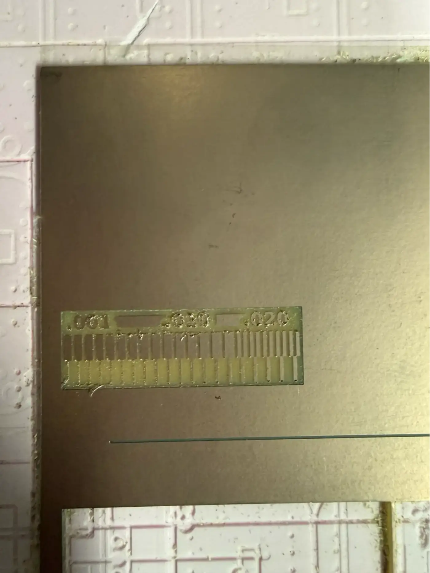 Trace width test milling in progress on the copper board – three zones (0.001", 0.010", 0.020" spacing) being cut side by side