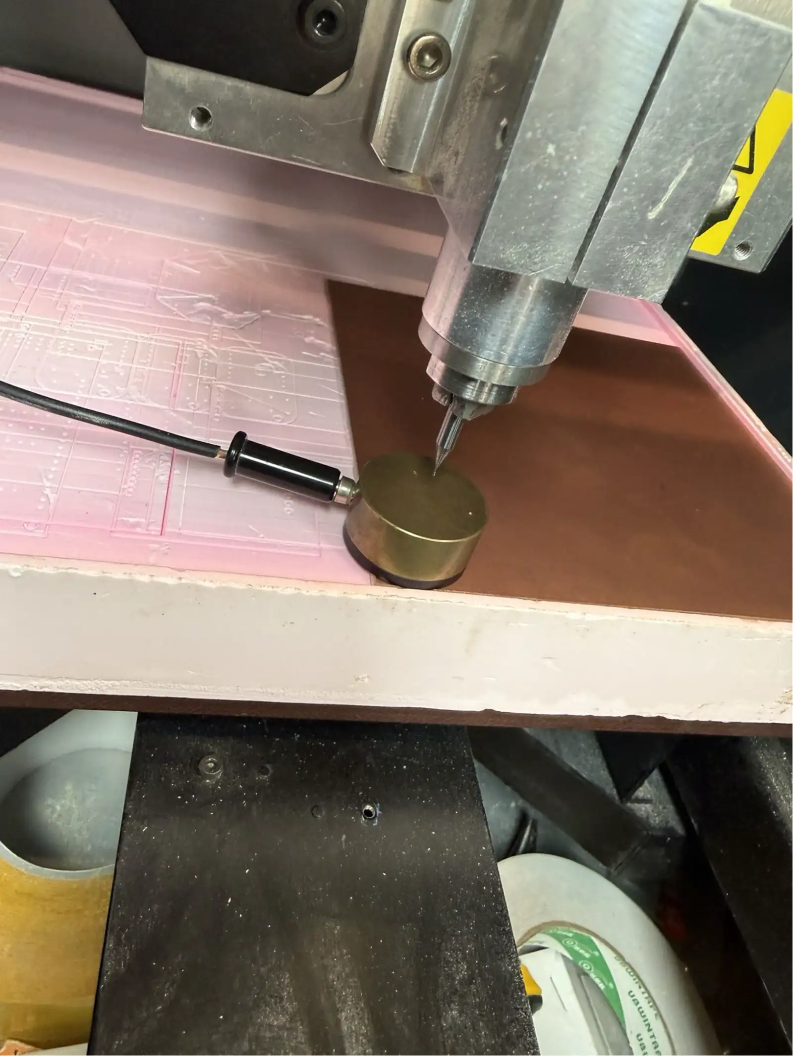 The Z-probe brass sensing disc placed on the copper board surface directly beneath the bit tip