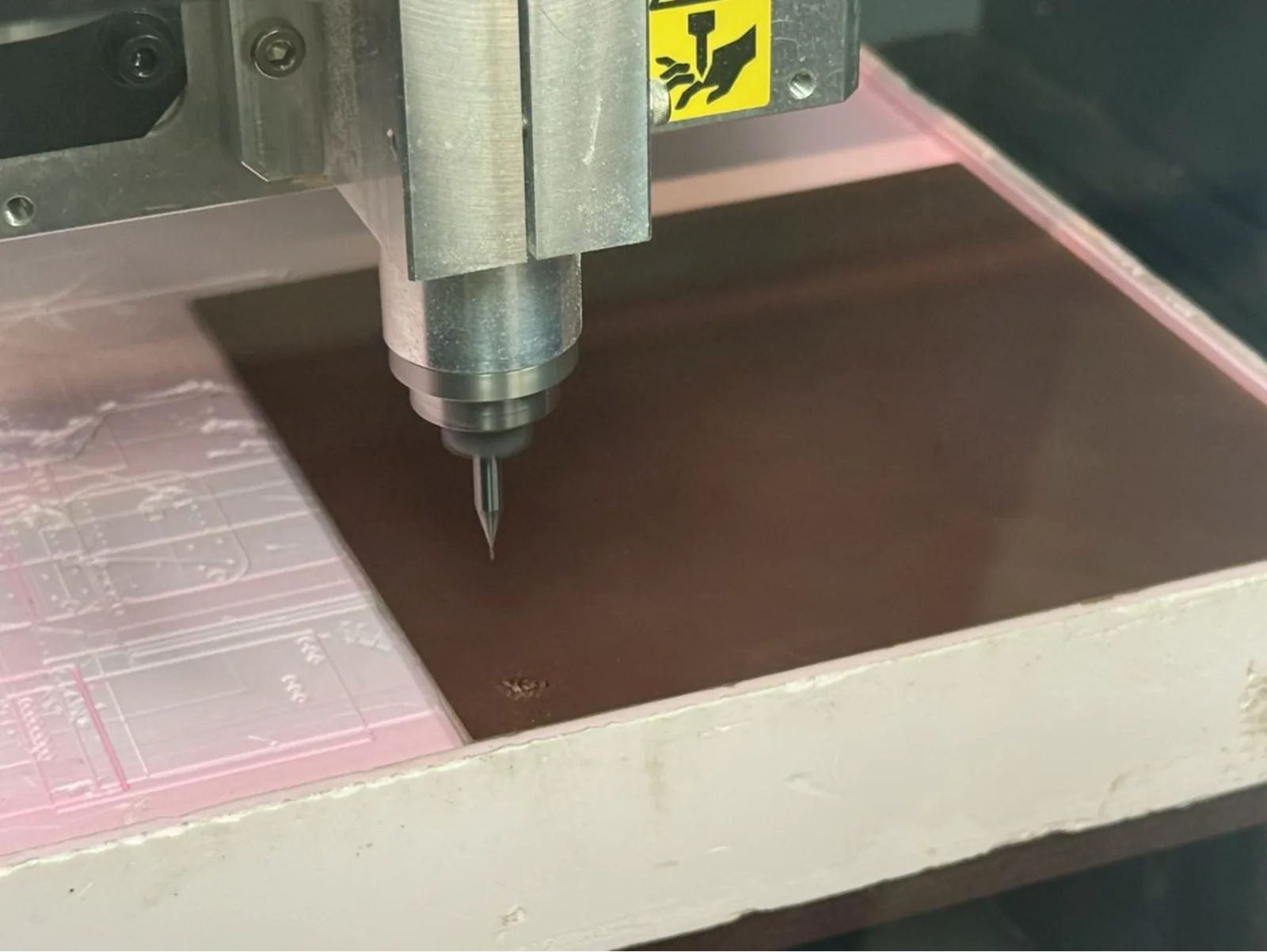 The V-bit engraving tip touching the copper surface at the start of the milling job – first contact with the board