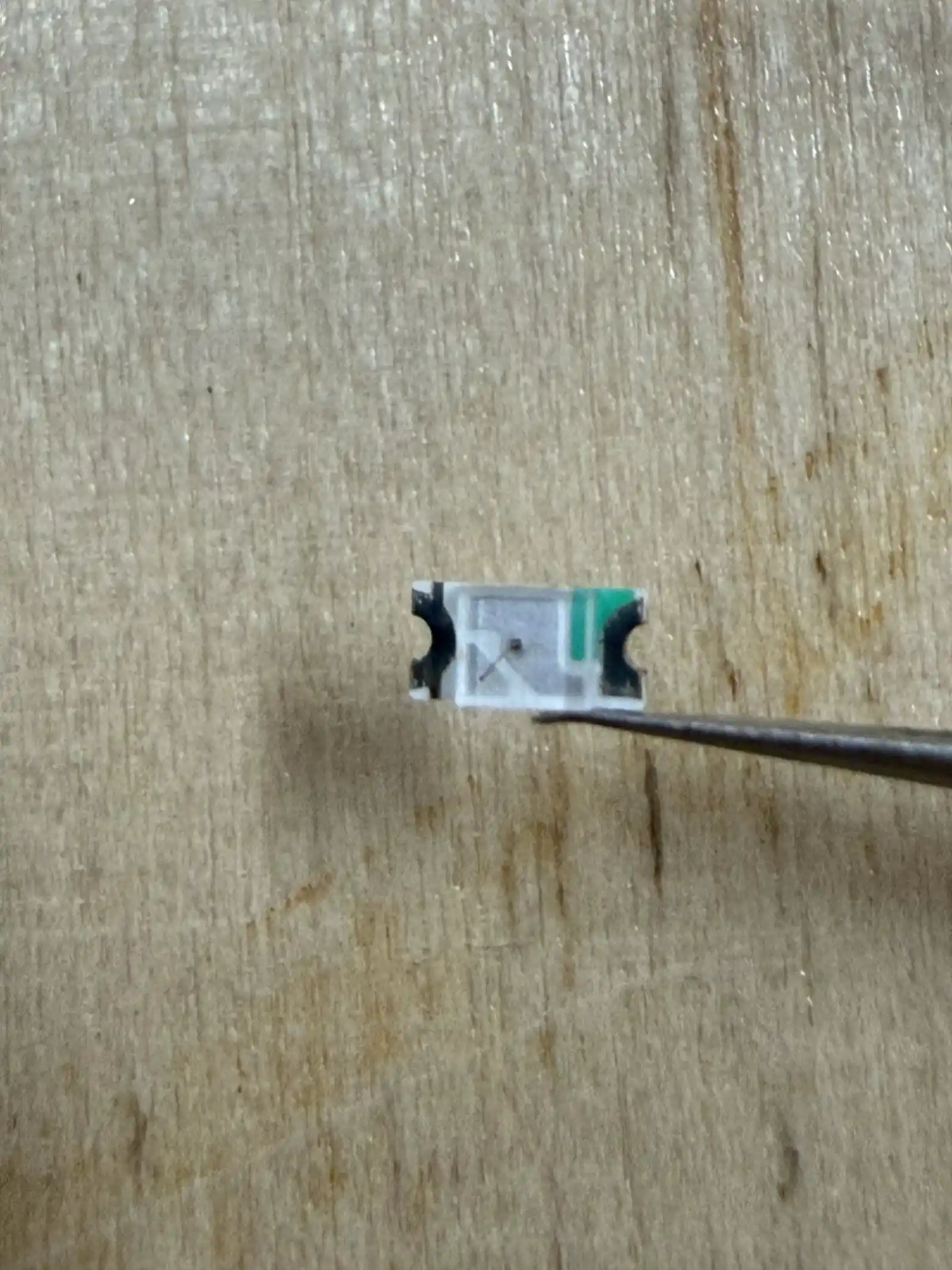 Holding a 1206 SMD LED with tweezers – these components require steady hands and good lighting