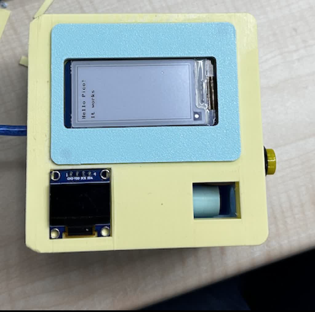 Version 1 “box” prototype — tall rectangular enclosure with e-ink and encoder on the bench