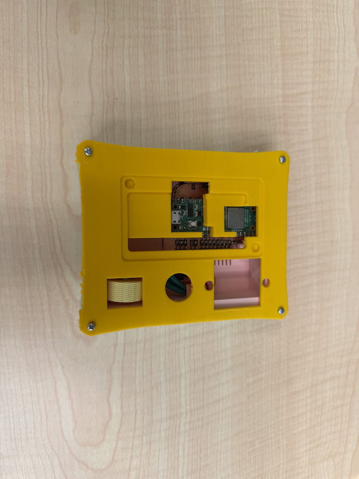 Yellow top opened — encoder, PCB, and wiring through internal cutouts