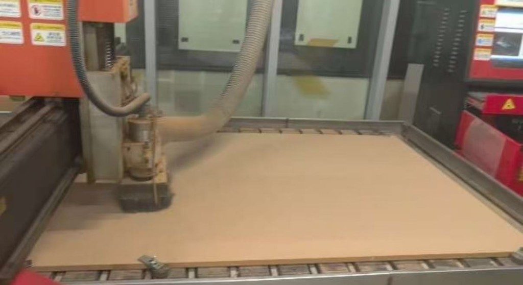 Plywood sheet loaded on the large-format CNC bed