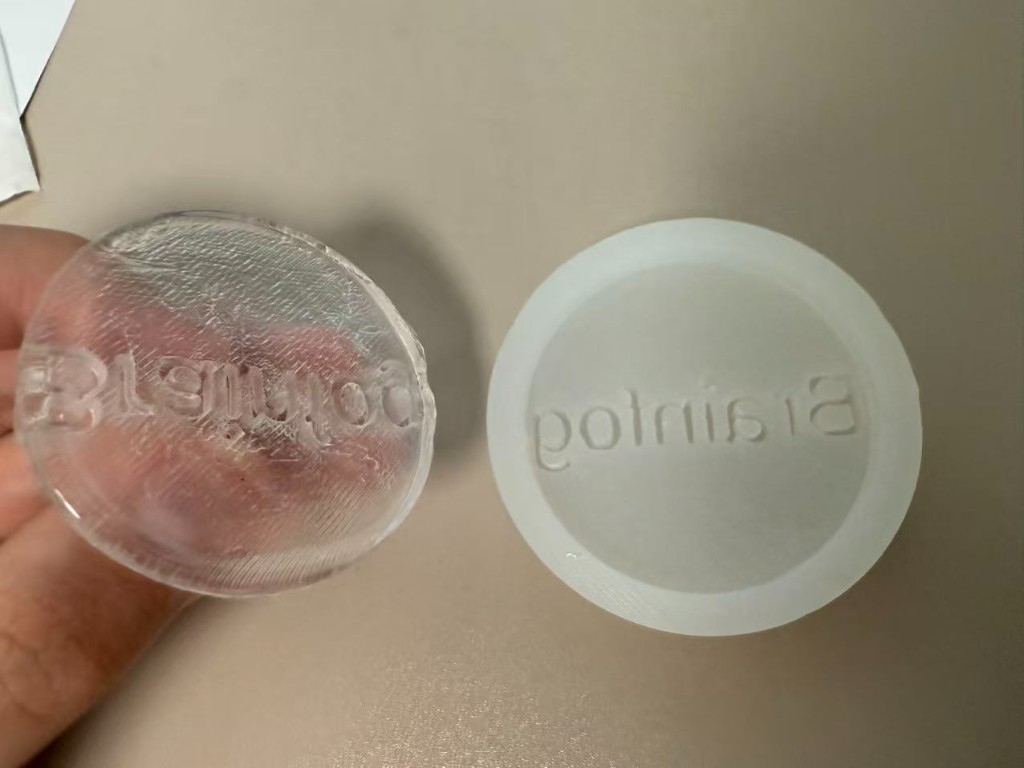 Clear resin Brainfog disc beside the silicone mold after demolding