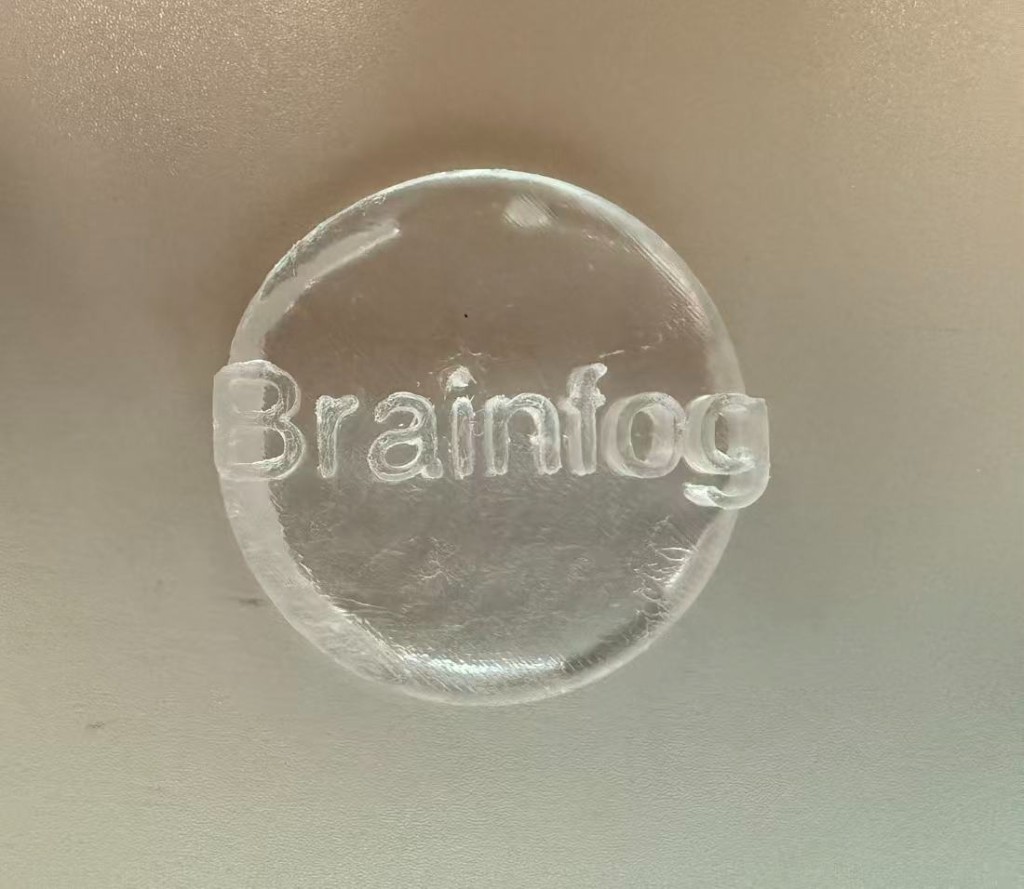 Finished clear resin Brainfog badge top view