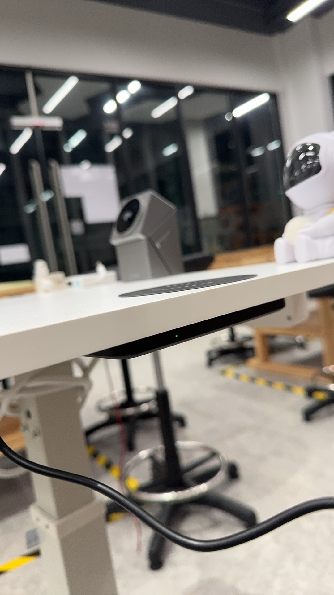 Side view of the height-adjustable desk showing the electric lifting column