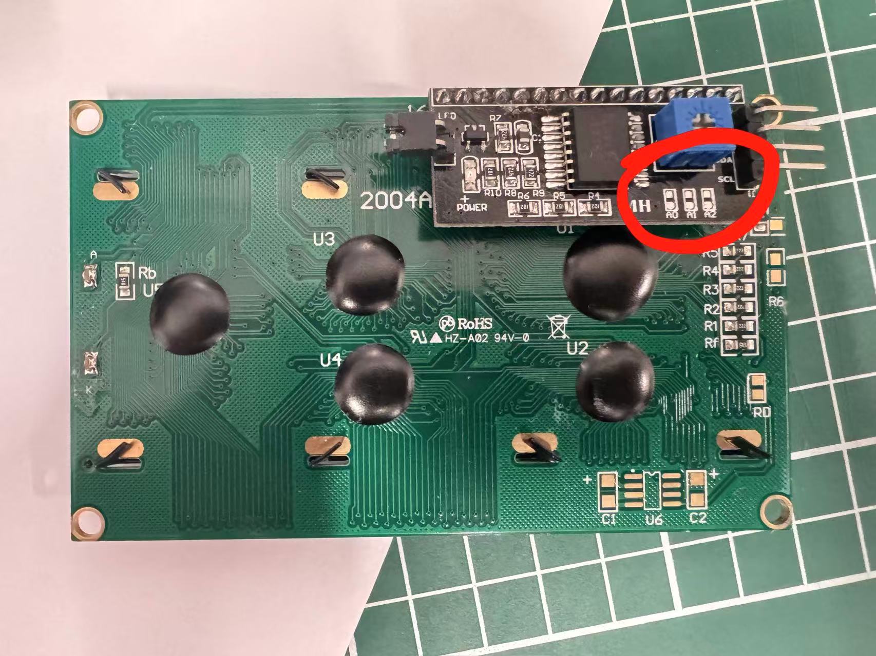 Back of a lab LCD2004 I2C backpack; three address jumper pads circled in red