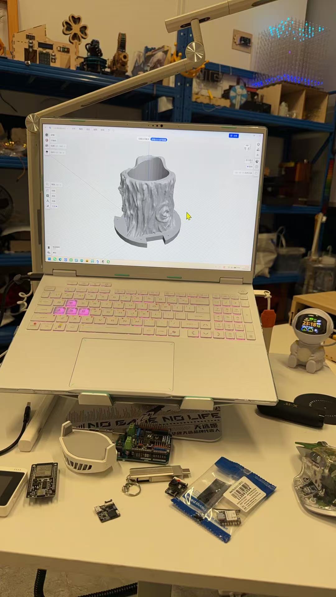Laptop on a desk showing a 3D model of the root planter and omni-wheel base in modeling software