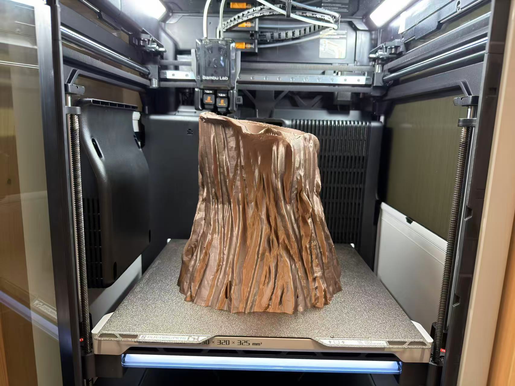 Later stage of FDM print: root planter geometry emerging above the wheel plate