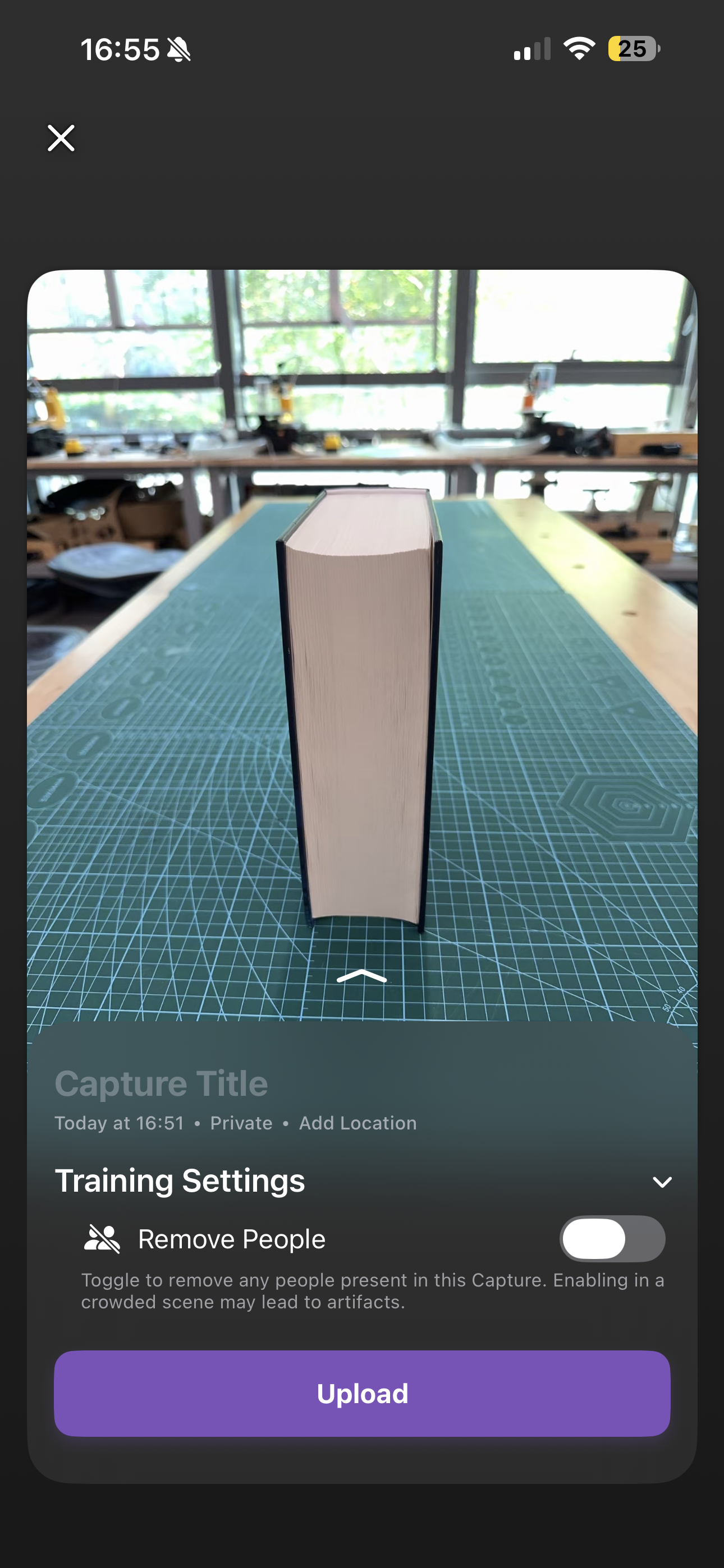 Luma 3D capture setup screen with a book standing on a cutting mat and upload button visible