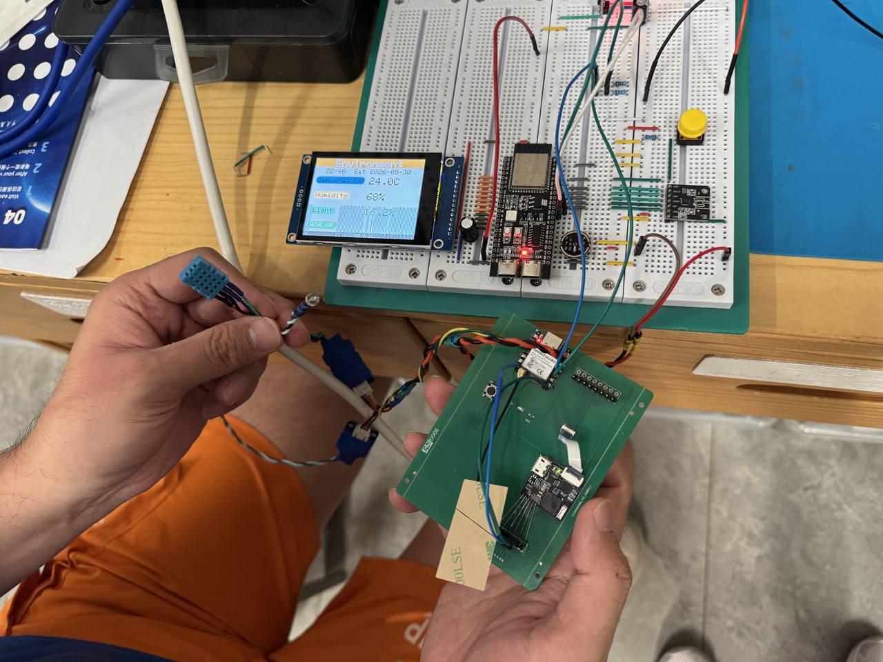 Rainbow wires from custom PCB to a breadboard-mounted OLED display