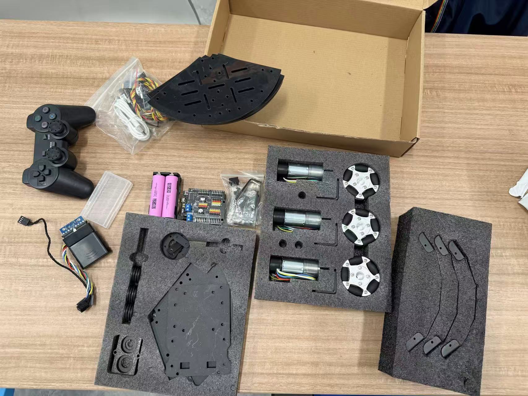 Purchased holonomic kit: motors, omni wheels, chassis plates, controller, PS2 remote, batteries