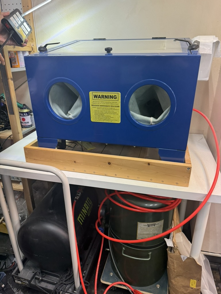 The sandblast machine — cabinet with compressed air and abrasive