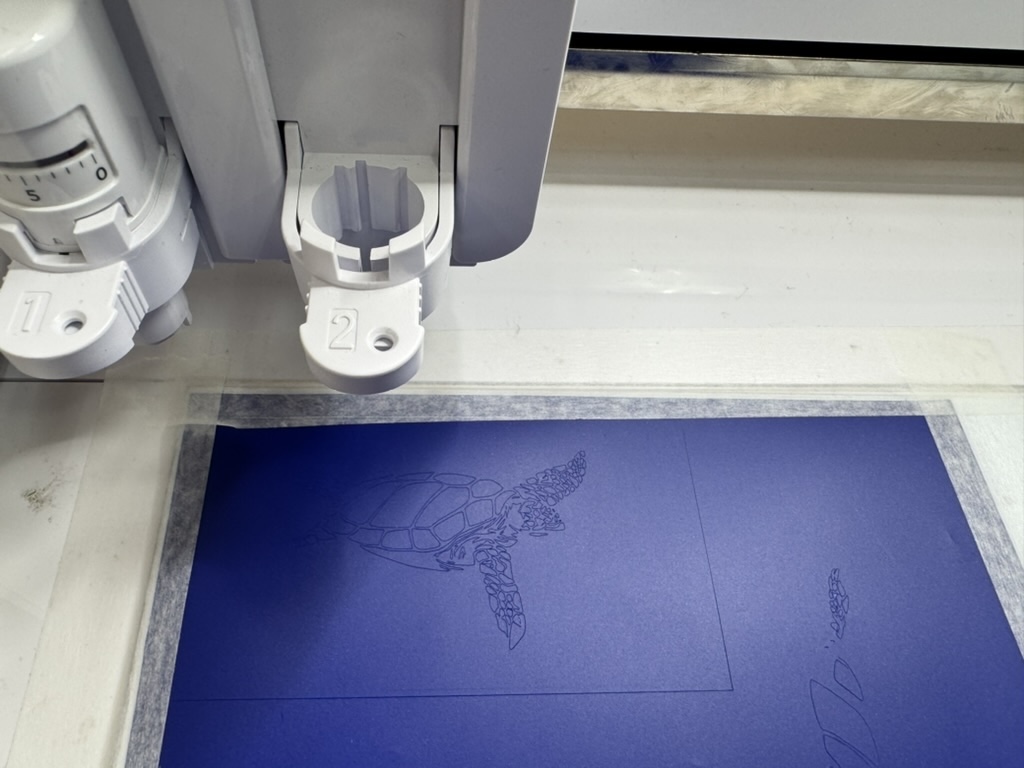 Turtle being cut on blue vinyl — too many small pieces to weed successfully