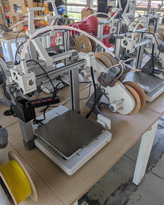 Bambu A1 with AMS Mini. FDM. Build Volume: 256mm x 256mm x 256mm. Max speed: 500mm/s. Open enclosure. The industry standard for entry level printing