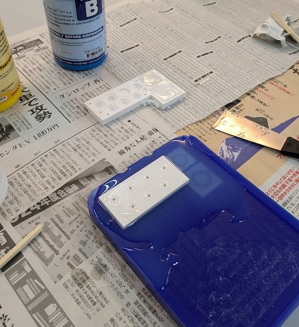 Here you can see my PLA plastic mold pressed into the wax mold as well as the button test that I talk about earlier. I definitely mixed too much silicone for this one so there's a lot seeping out on all sides