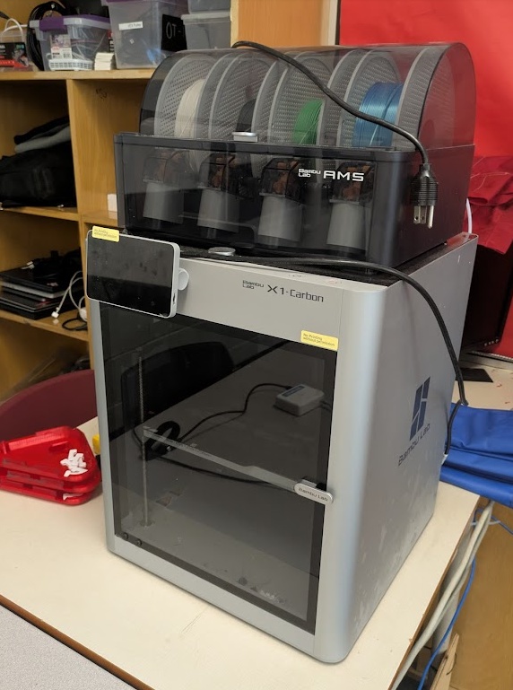 Bambu X1C with AMS. FDM. Build Volume: 256mm x 256mm x 256mm. Max speed: 500mm/s. Closed enclosure. This is the printer I use the most at work. It does a great job of self maintenance and detection with it's LiDAR scanner.