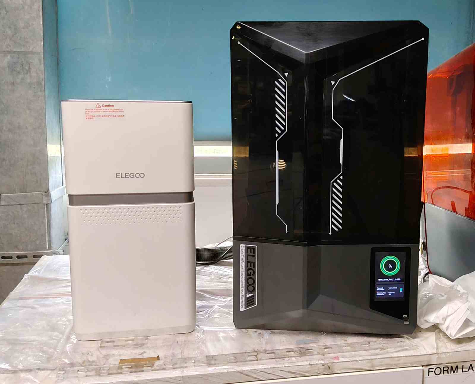 ELEGOO Saturn 4 Ultra and the exhaust machine on the left.