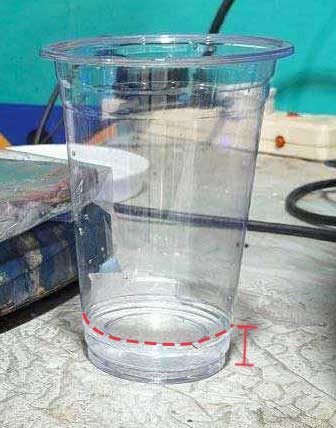 Water is poured into the flask and pattern to get the volume of silicone needed. The water is poured into a transparent cup and the measurement is marked.