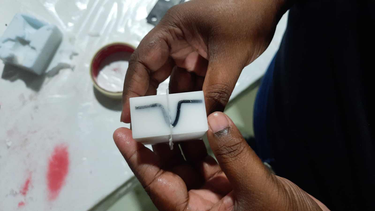 A thin layer of silicone seeped under the pattern and covered it. There are flash lines along the two sides where the flask joined.