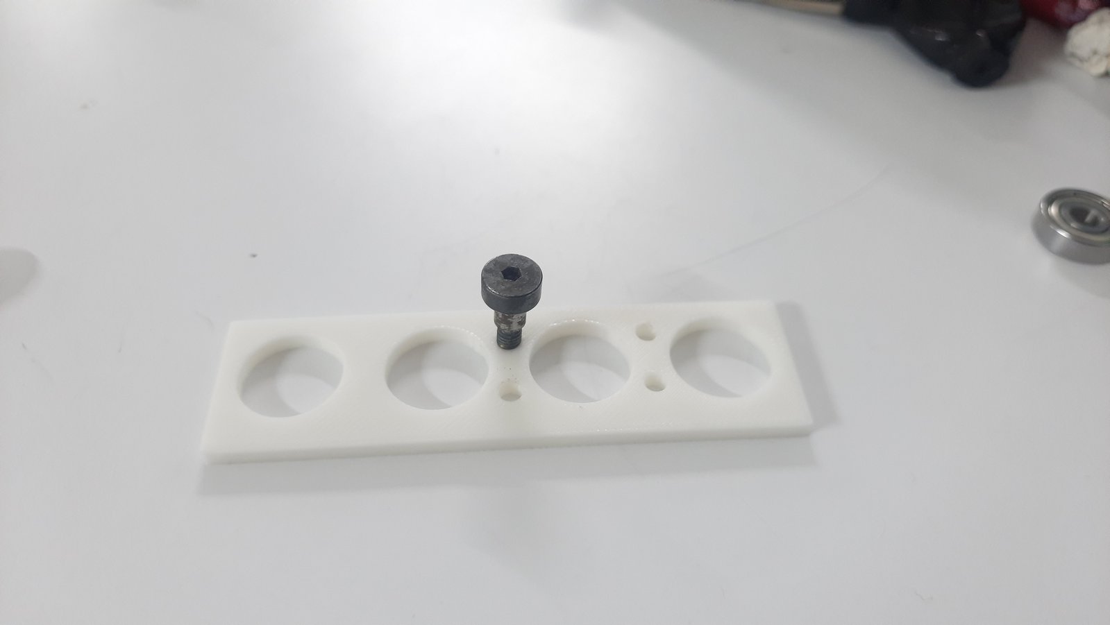 The shoulder bolt thread was measured and a dedicated test jig was designed to determine the correct thread fit before final fabrication.