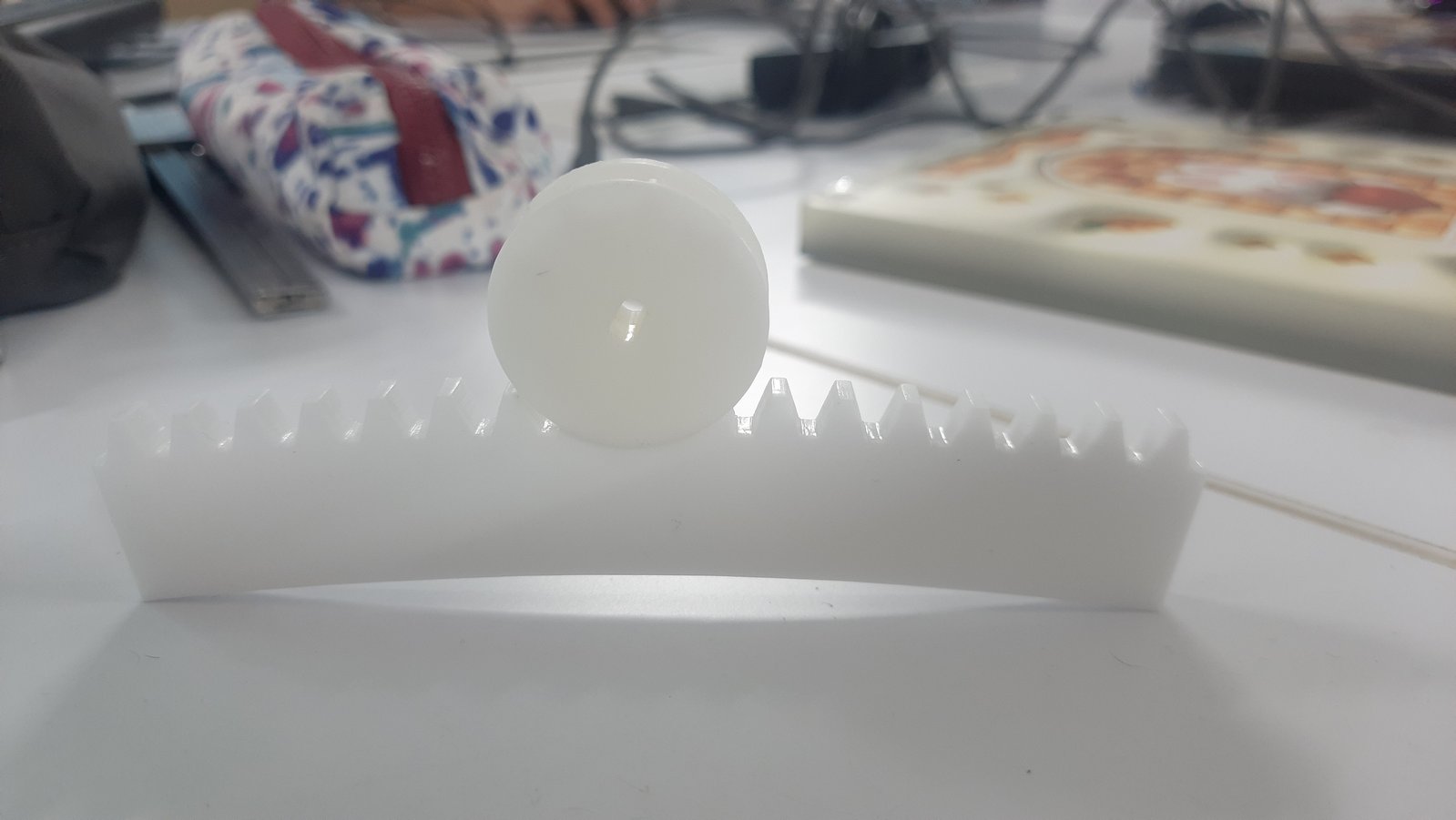 The 3D printed gear mounted onto the laser cut acrylic gear to verify alignment and fitment within the mechanism.