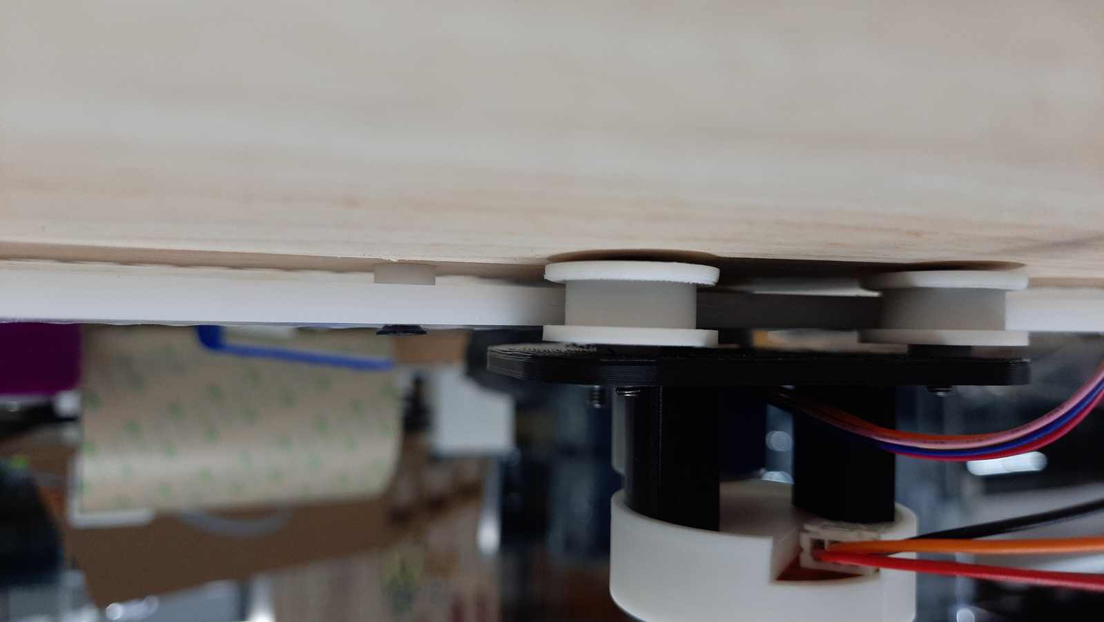 Spacers were used to position the acrylic gear away from the wooden back panel. This clearance provided sufficient space for the bearing assembly and slider mechanism to move freely.