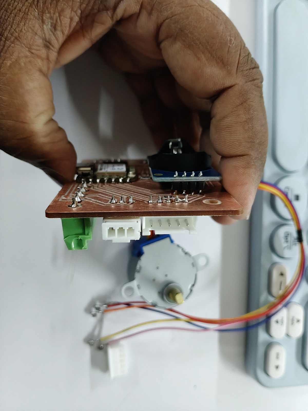 Side view of the assembled PCB. The JST connectors and header pins can be seen extending from the board, providing connections to the external modules.