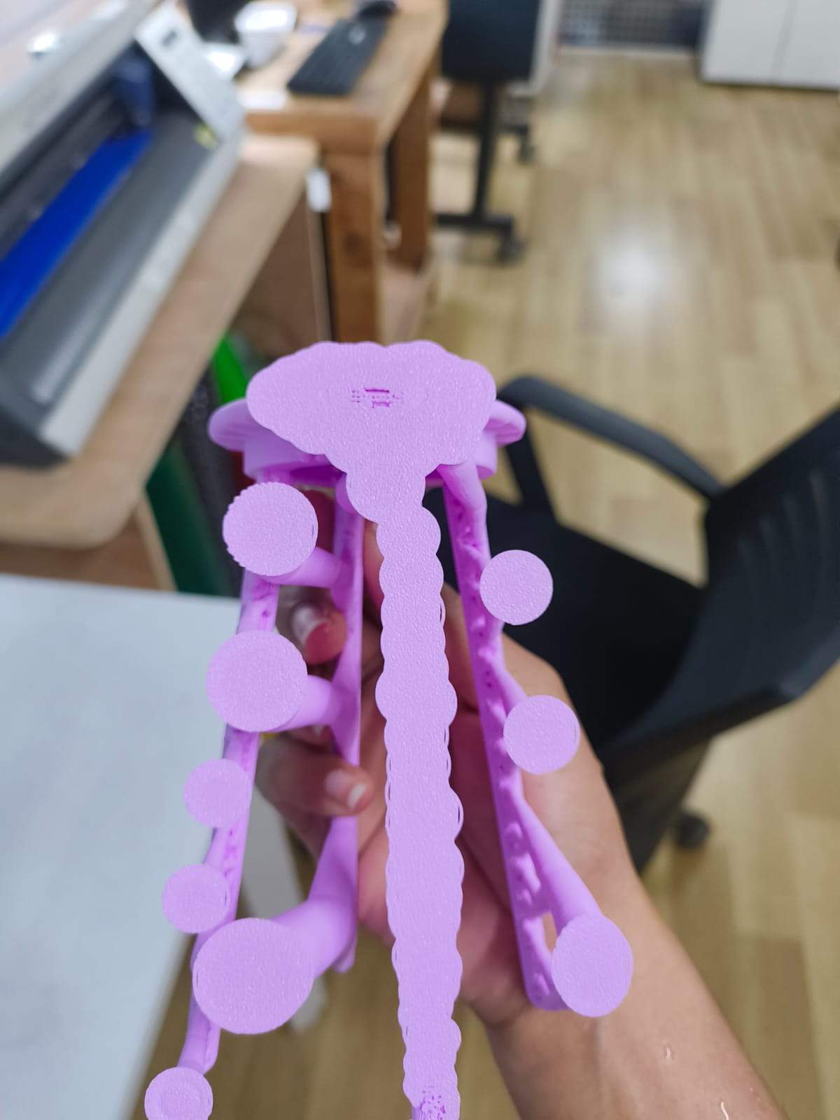 3D printed stool held in hand with support structures still attached