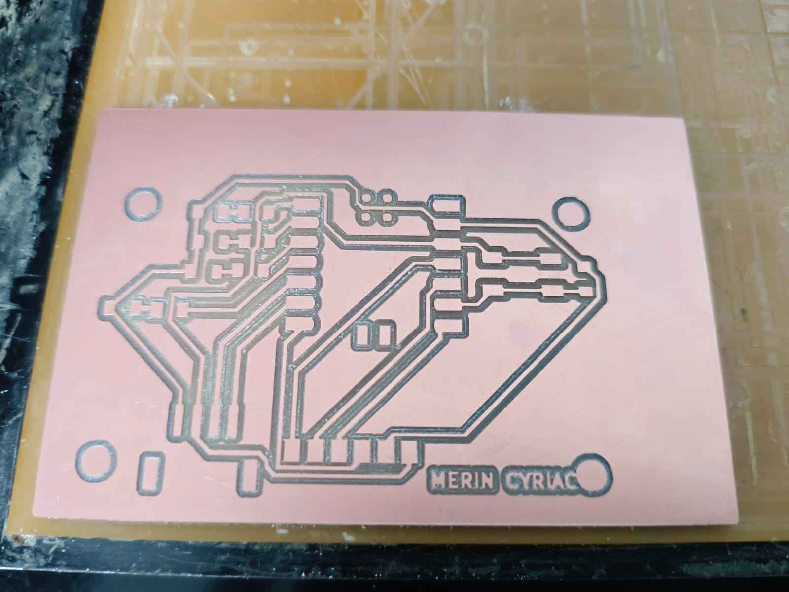 Freshly milled PCB showing clean copper trace isolation cuts from the V-bit