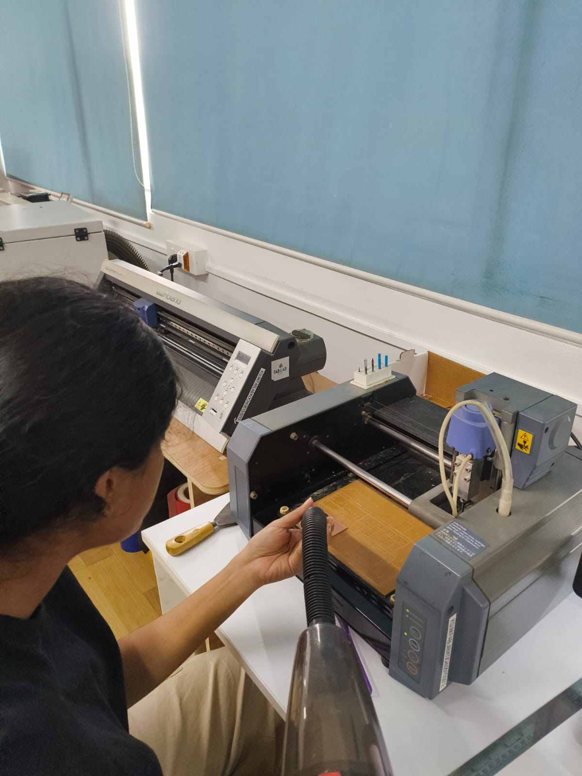 Vacuuming copper dust and FR1 debris from the milled board and machine bed