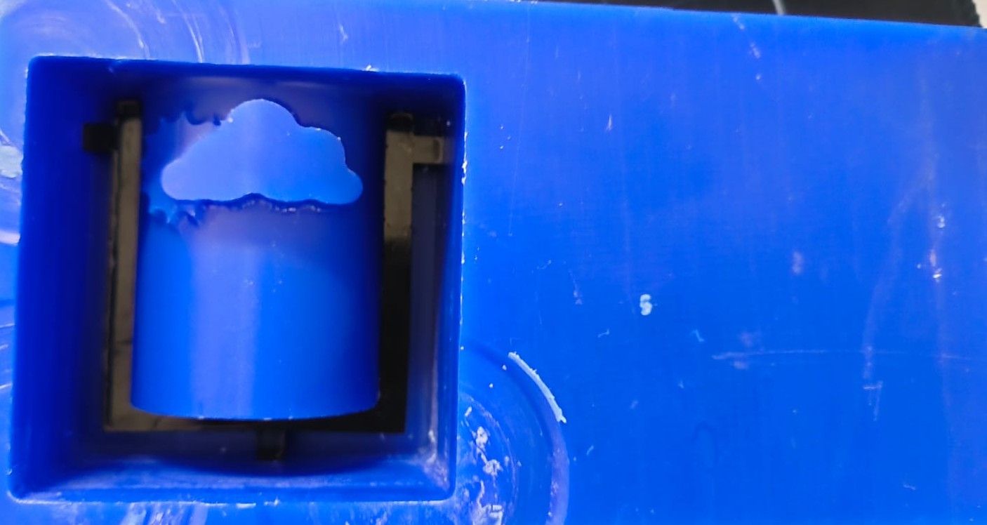 Wax mold with an acrylic frame built around it to form the outer boundary for silicone pouring