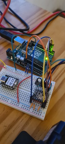 Breadboard bring-up: an Arduino UNO R3 wired to a TMC2209 driver, with a XIAO RP2040 also on the board but not driving, jumper wires, and a lit status LED.