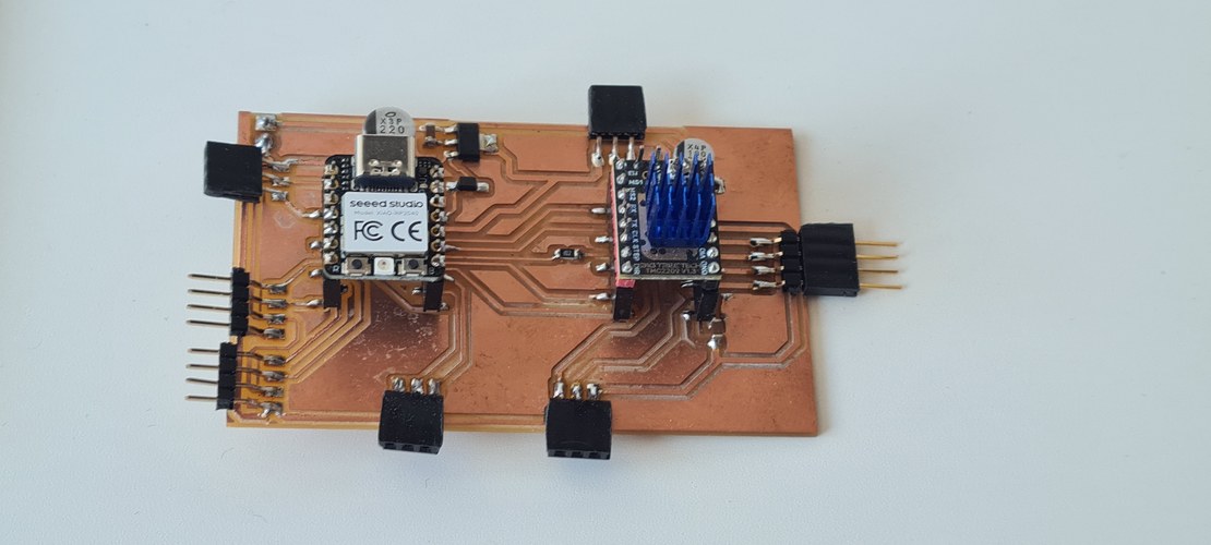 The milled copper control PCB populated with the XIAO RP2040 and the TMC2209 driver with its blue heatsink.