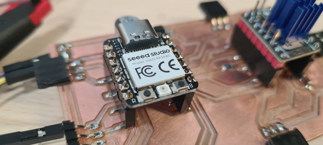 Close-up of the Seeed XIAO RP2040 seated in its socket on the milled board, USB-C connector facing up.