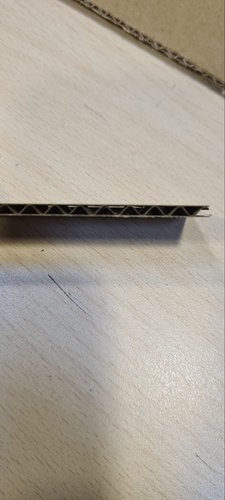 Cross-section of the single-flute corrugated cardboard showing the wavy inner layer between two liners.