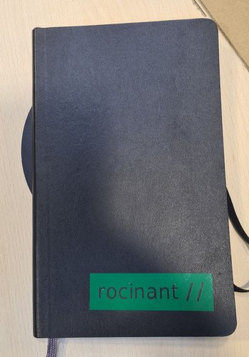 Green block with rocinant // reversed out of it, applied on a navy hardcover Moleskine.