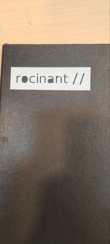 White block with rocinant // in black, applied on a black hardcover notebook.